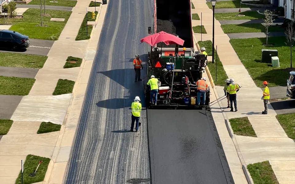 A crew repaving a neighbourhood street, seen from above