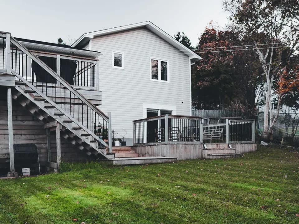 A house with a new deck and a freshly cut lawn