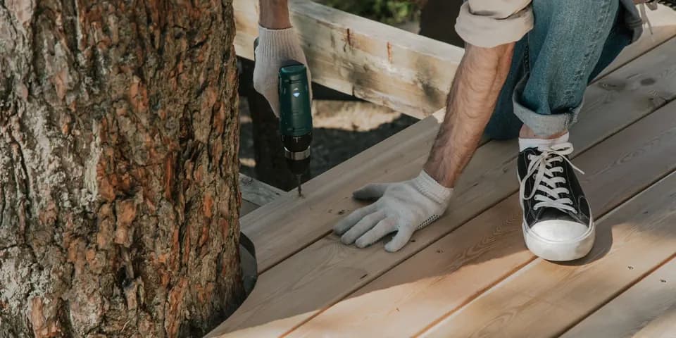 A builder driving screws into new deck boards