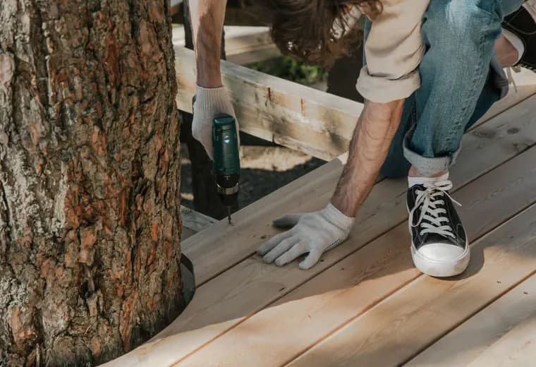 A builder fastening new deck boards