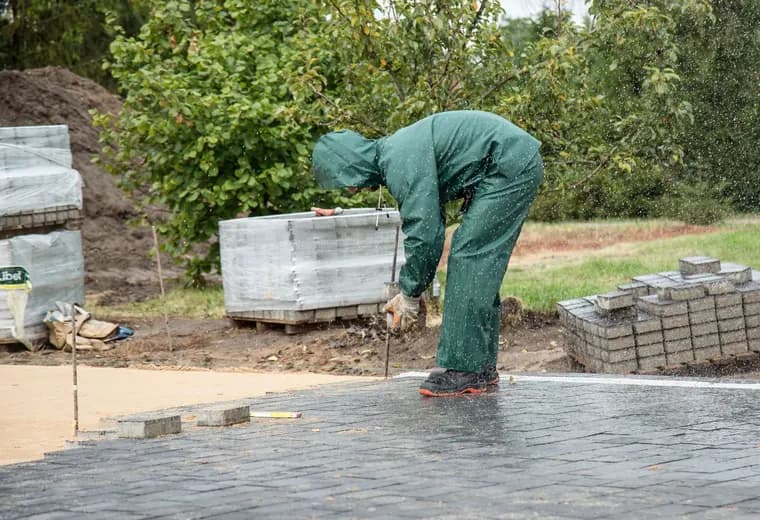 A worker laying interlock pavers