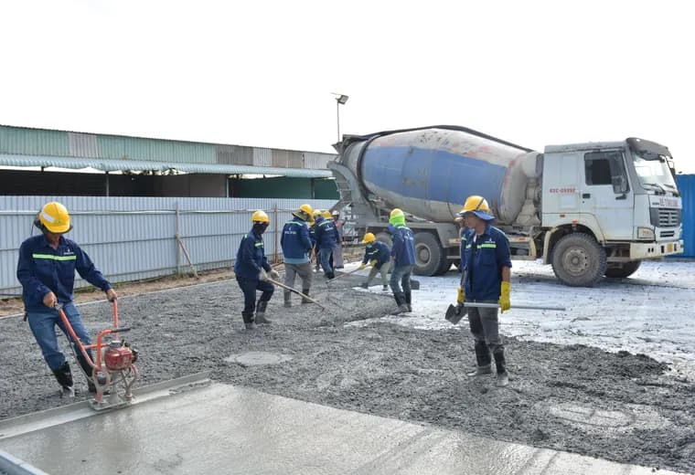 A concrete crew working beside a mixer truck